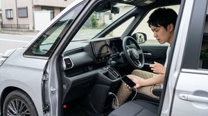 シガーソケットに充電ケーブルを接続したスマートフォン