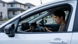 燃料残量警告灯が点灯した車を運転する様子
