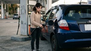 車の給油口に給油ノズルを差し込んで給油する様子