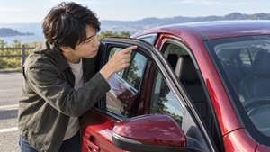 ドア上部のゴムシールを確認する運転者