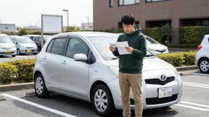 駐車場で書類と免許証を確認するドライバー