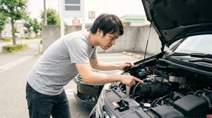 エンジンルーム内のエアコンコンプレッサーを確認する様子
