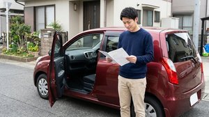 自動車名義変更書類を確認する男性