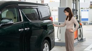 給油所で給油口が閉じたままの車両を見つめる様子