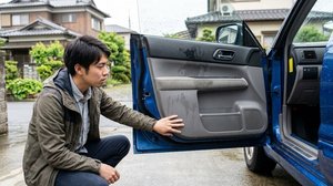 濡れたドア内側を見つめる男性