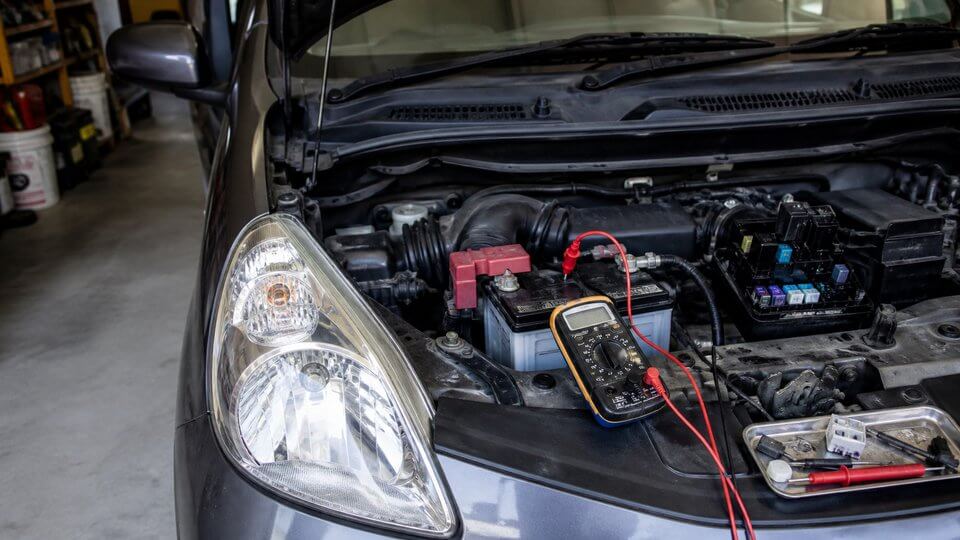 バッテリーにテスターを接続して暗電流を点検する様子