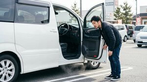車の下から上がる煙と排気系を点検する様子