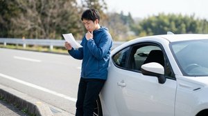 交通違反の反則切符を確認するドライバー