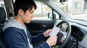 車内で自動車保険の書類を確認する場面