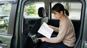後席エアコンの取扱説明書を確認する女性